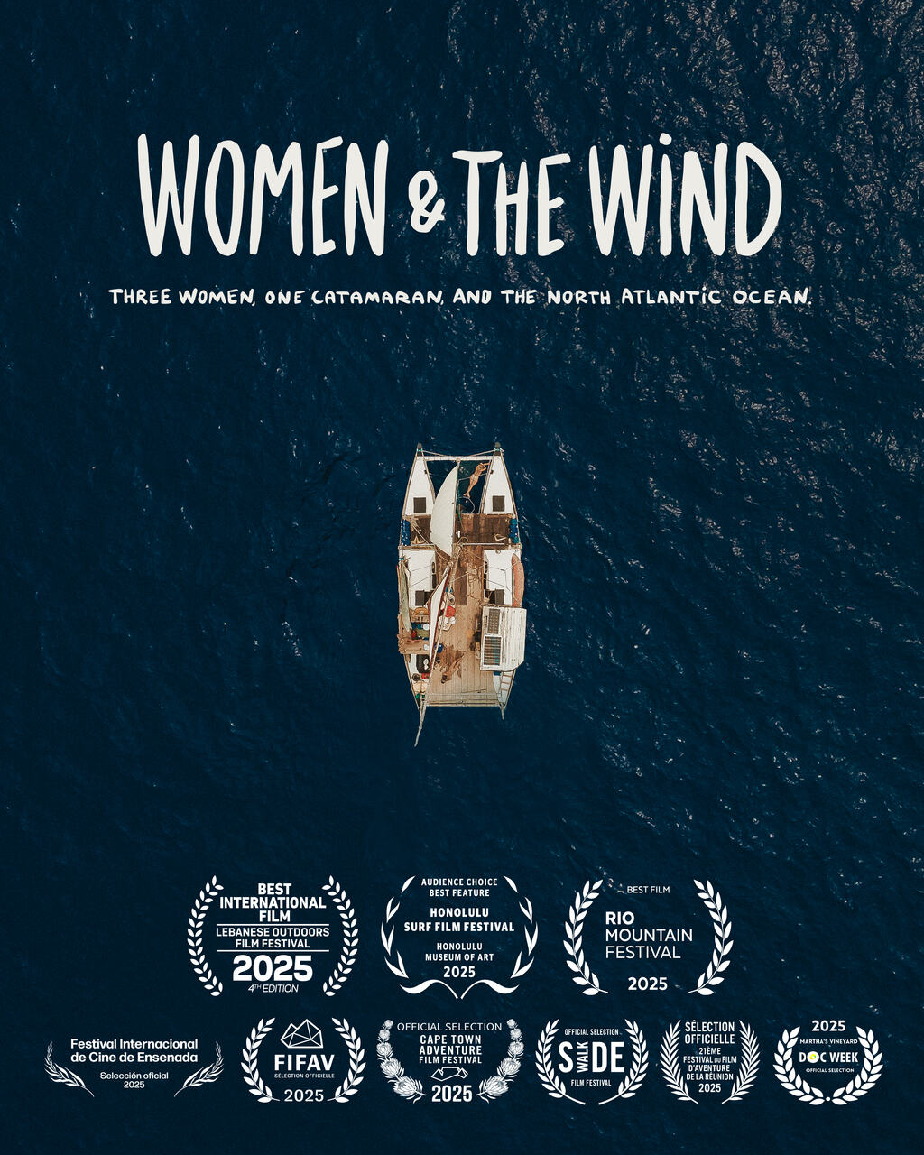 Na zdjęciu w ujęciu z góry ocean, a na nim mały katamaran.