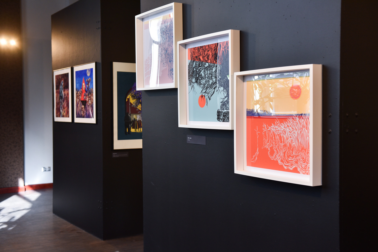 The photo shows a wall on which three framed graphics hang.