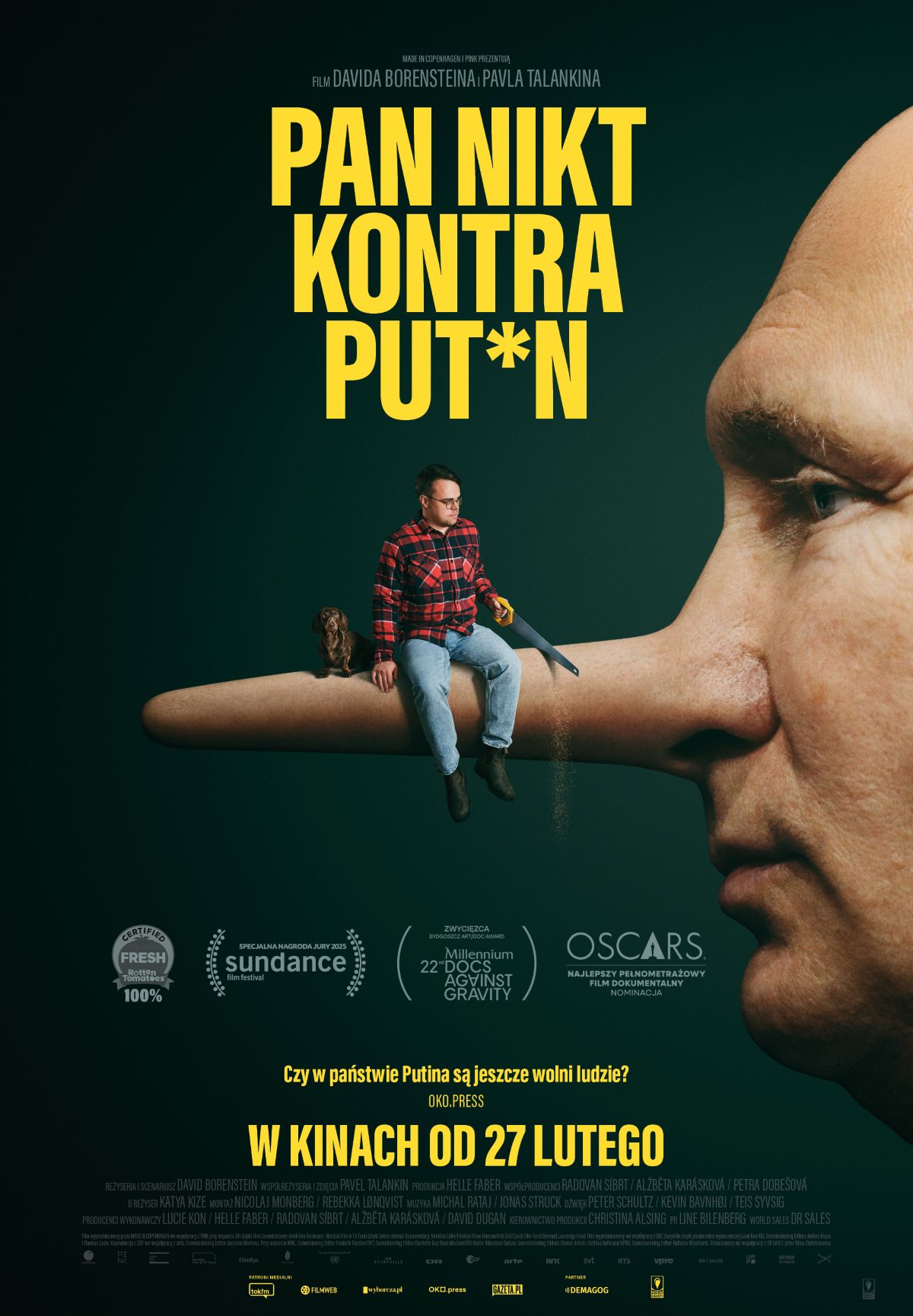 plakat - portret osoby przypominającej Putina z profilu, z nosem jak pinokio, na nosie siedzi mężczyzna w dżinsach i koszuli w kratę.