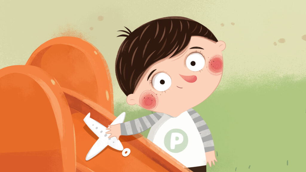 chłopiec w pasiastej bluzce z napisem P, bawi się na pomarańczowej zjeżdżalni samolocikiem