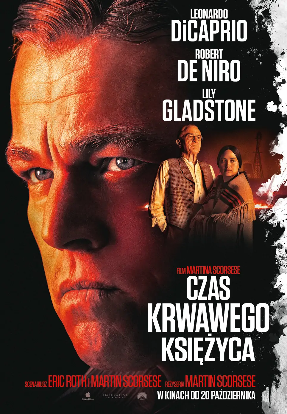 Plakat. Twarz mężczyzny oświetlona czerwonawym światłem, a po jej prawej stronie dwie postaci - kobieta Indianka okryta narzutką i starszy mężczyzna w białej koszuli i kamizelce, w okularach.
