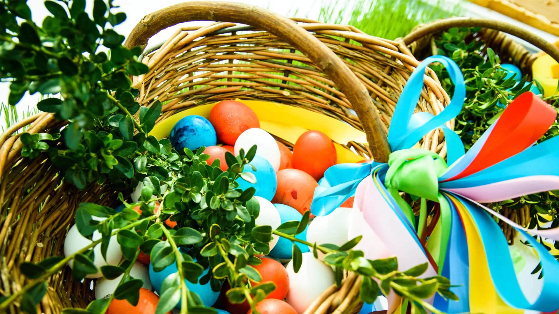 Kosz z kolorowymi jajkami.