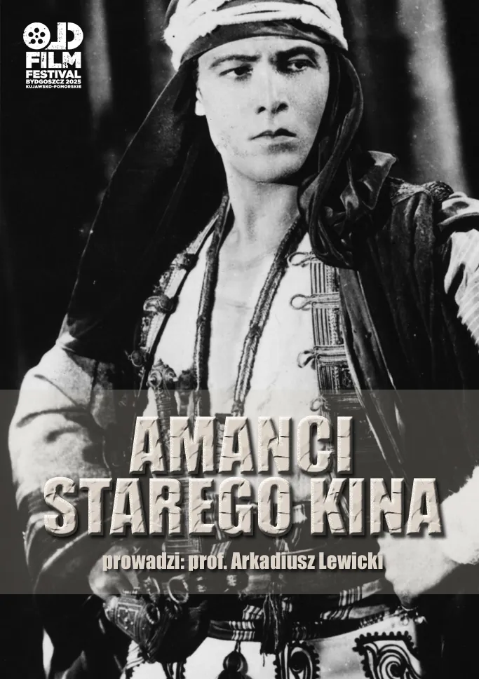 kadr z czarno-białego filmu - młody mężczyzna w kapturze, rozpiętej koszuli, obwieszony ozdobami i bronią