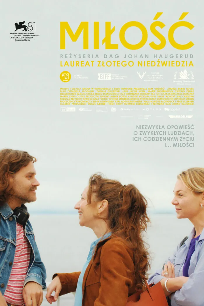 plakat. na tle morza mężczyzna w półdługimi włosami, w dżinsowej kurtce, uśmiecha się do kobiety szatynki w brązowej kurtce, za nią stoi blondynka.