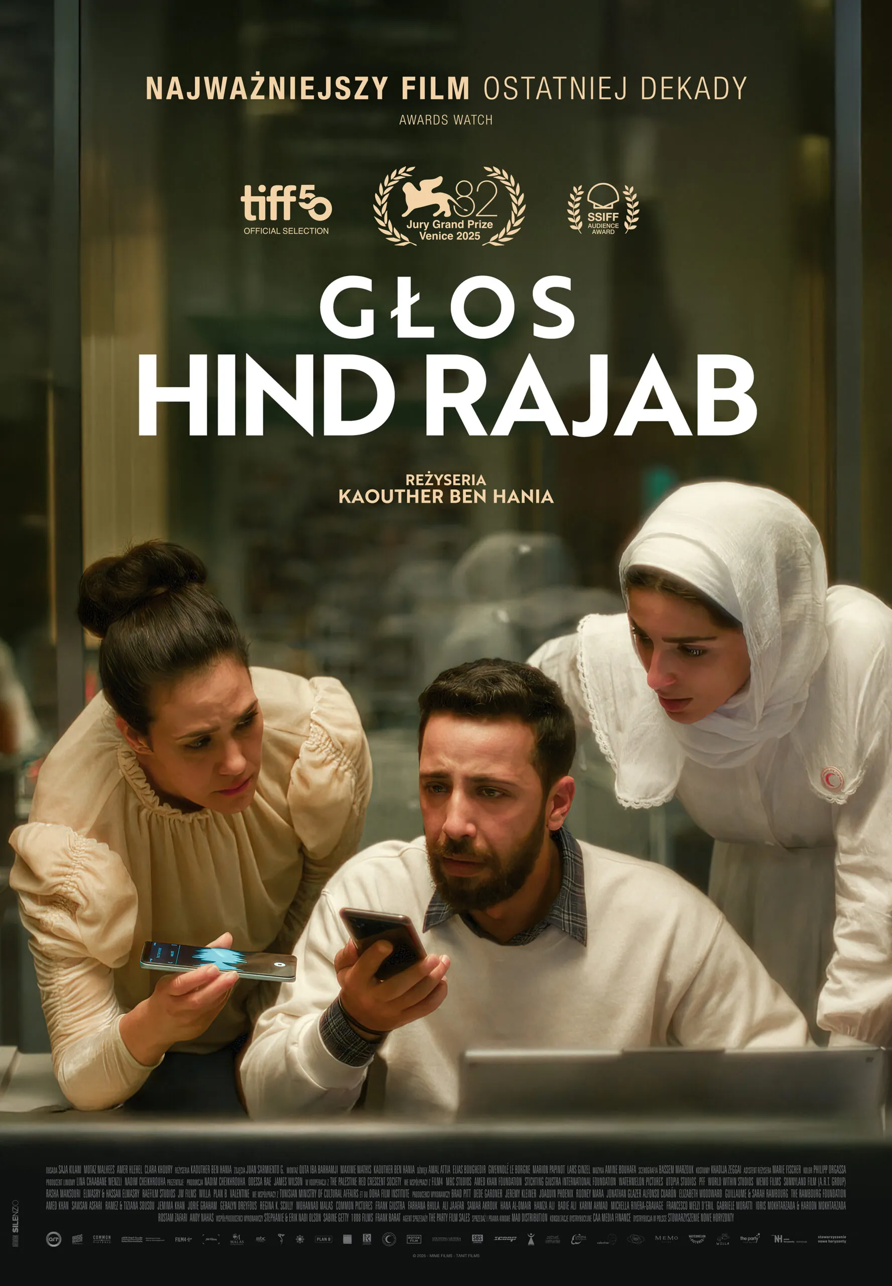 Plakat filmowy w stonowanej, zielono-beżowej kolorystyce. W centrum kadr z trzema osobami pochylonymi nad stołem: mężczyzna trzyma telefon i patrzy w ekran z napięciem, obok niego dwie kobiety — jedna w jasnej sukni, druga w białym stroju i chuście — również wpatrują się w urządzenia mobilne. Scena rozgrywa się we wnętrzu przypominającym biuro lub centrum kryzysowe. U góry duży biały tytuł „Głos Hind Rajab”, poniżej informacja o reżyserii Kaouther Ben Hanii oraz logotypy festiwali i nagród filmowych. Na dole blok drobnych napisów produkcyjnych.